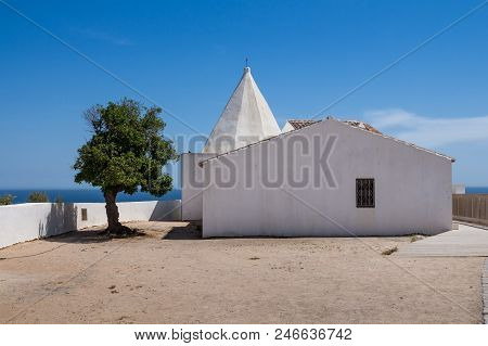 Small Chapel Of Nossa Senhora Da Rocha On A Cliff In Porches, Algrave, Portugal. White Facade Of The