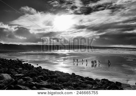 Runners On An Irish Beach At Late Evening With Reflections And Silhouhetting
