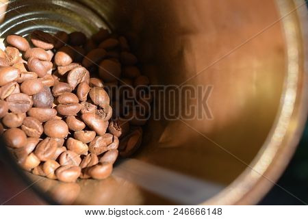 In Metal Jar Handful Of Coffee Beans Illuminated By Sunlight