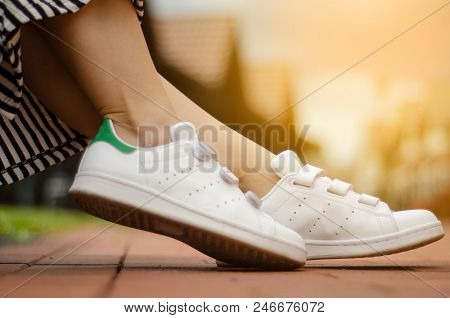Female Legs In Street Sneakers Nature Sun Skyon Blur Background Beauty Fashion