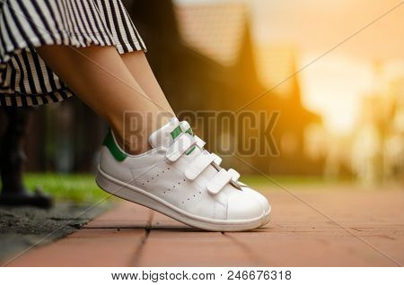 Female Legs In Street Sneakers Nature Sun Skyon Blur Background Beauty Fashion