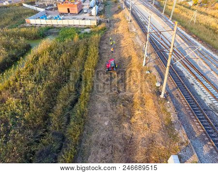 The Bulldozer Clears The Space Along The Railway Tracks. Raking Of Reeds By Bulldozer.