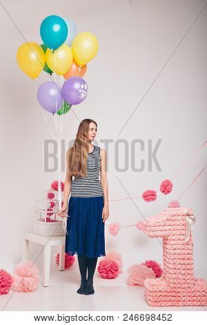 The Blonde Woman With The Colored Balls On A White Background. Studio Portrait Of An Attractive Girl
