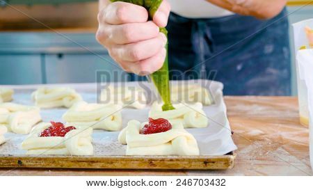 Professional Baker Adding Jam On Top Of Sweet Baking Before Put It Into Oven At Commercial Kitchen, 