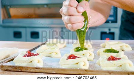 Professional Baker Adding Jam On Top Of Sweet Baking Before Put It Into Oven At Commercial Kitchen, 