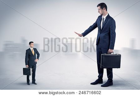Giant businessman being afraid of small serious executor with suitcase