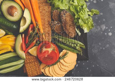 Vegetarian Different Snacks And Fresh Vegetables On A Dark Background. Healthy Vegan Food Concept.