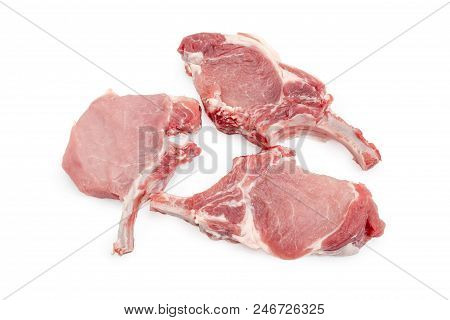 Three Uncooked Pork Loin Chops With Partly Frenched Ribs On A White Background