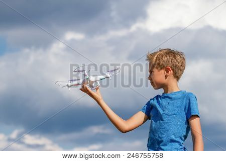 Child Playing With Drone Outdoors Against Blue Sky