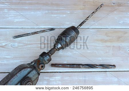 Old Hand Drill Against The Background Of Boards