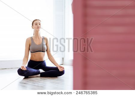 Photo Of A Young, Beautiful Woman, Doing Yoga And The Lotus Posity In The Studio, Beautiful And Heal