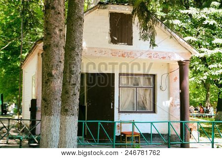 An Abandoned Broken House In The Woods. The Paint Is Flaking And It Gives A Lonely Feeling.