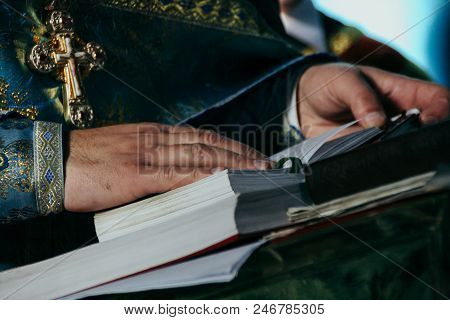 Voyutyn, Ukraine - 14 October 2008: Hands Of Priest On The Bible. Shallow Depth Of  Fielf.