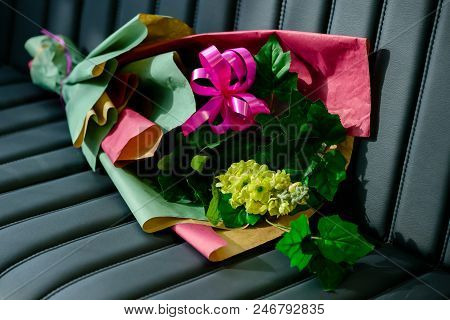 Amazing Handmade Bouquet With Wrapped In Pink Gift Paper And Decorated With Pink Ribbon On Leather B
