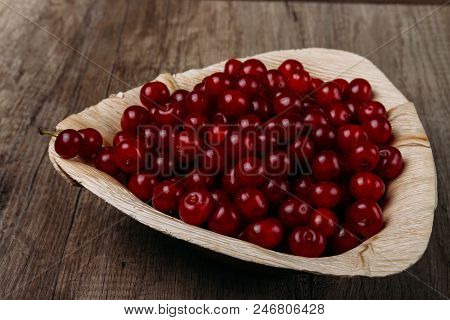 Fresh Red Cherries In A Wooden Plate On A Wooden Table. Wooden Plate On A Wooden Background. A Plate