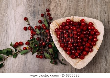 Fresh Red Cherries In A Wooden Plate On A Wooden Table. Wooden Plate On A Wooden Background. Next To