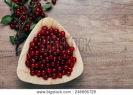 Fresh Red Cherries In A Wooden Plate On A Wooden Table. Wooden Plate On A Wooden Background. Next To
