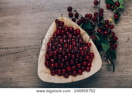 Fresh Red Cherries In A Wooden Plate On A Wooden Table. Wooden Plate On A Wooden Background. Next To