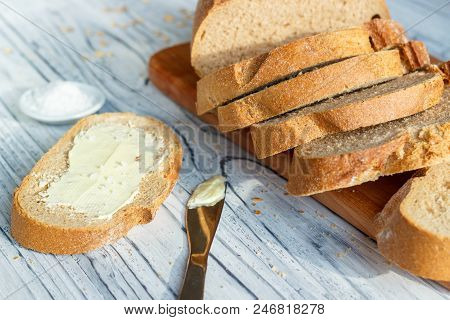 Still Life With Bread And Butter In A White Plate On A Wooden Background