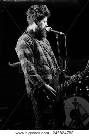 Musician With Beard Play Electric Guitar Lighted By Spotlight. Man With Enthusiastic Face Holds Guit
