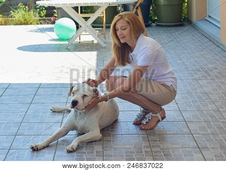 Young Blonde Girl Hugging Her Dogo Argentino
