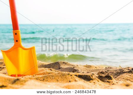 Summer Heat, Sunny Day Beach Tyrrenian Sea Horizon With Orange Toy Shovel Standing In Sand. South Of