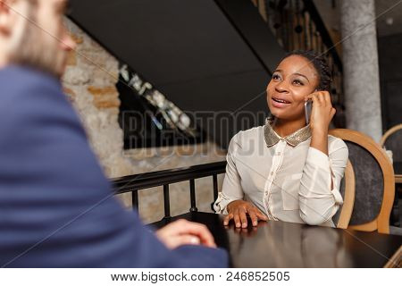 A Man In A Blue Jacket Is Taking An Exclusive Interview From A Pretty Afro-american Woman In A White