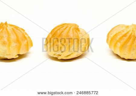 Row Of Three Profiteroles Isolated On The White Background.