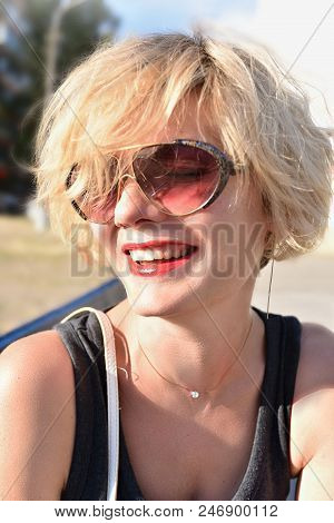 Portrait Of Young Beautiful Blonde Woman In Glasses And Smiling