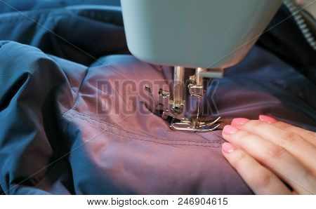 Close-up Of Talor's Hands Sews To Blue Jacket Leather Inserts On Sewing Mashine.