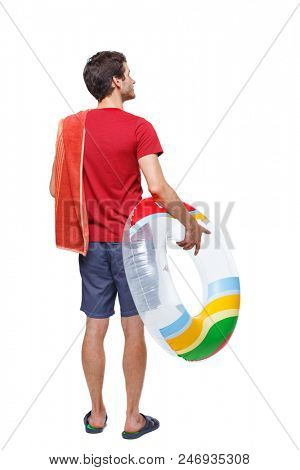Back view of a man in shorts with an inflatable circle. The guy on the beach. Rear view people collection.  backside view of person. Isolated over white background. young guy looks around at the beac