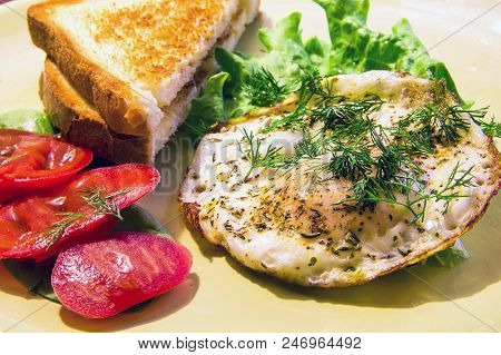 Breakfast Of Fried Eggs With Fresh Tomatoes, Lettuce And Hot Toast