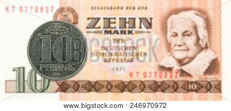 10 Pfennig Coin Against Historic 10 East German Mark Bank Note
