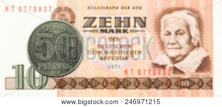 50 Pfennig Coin Against Historic 10 East German Mark Bank Note