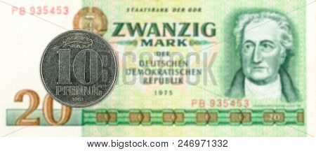 10 Pfennig Coin Against Historic 20 East German Mark Bank Note
