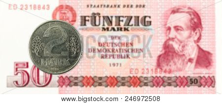 2 Mark Coin Against Historic 50 East German Mark Bank Note