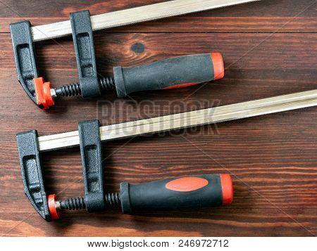 Two Clamps For Working With Wood Lying On A Wooden Board