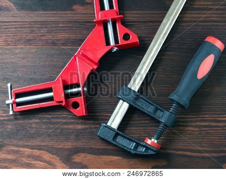 Set Of Clamps For Working With Wood Lying On A Wooden Board