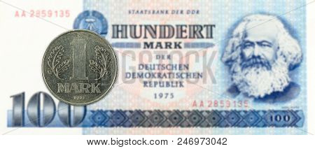 1 Mark Coin Against Historic 100 East German Mark Bank Note