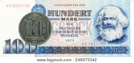 10 Pfennig Coin Against Historic 100 East German Mark Bank Note