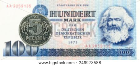 5 Pfennig Coin Against Historic 100 East German Mark Bank Note