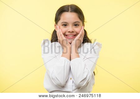Full Of Excitement. Girl Happy Smiling Face Touches Her Cheeks Yellow Background. Schoolgirl Can Not