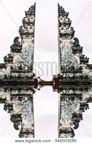 Couple At The Bali Gate. A Man And A Woman Traveling On The Island Of Bali Indonesia. The Couple Tra