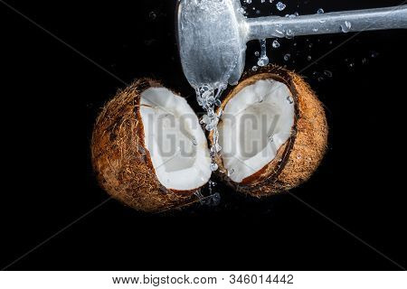 Smash Coconut On A Black Background With An Iron Hammer Blow, Spray Of Coconut Milk