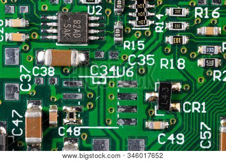 Green Card Computer Board With Brown Microcircuits And Various Electronic Components, Top View, Macr
