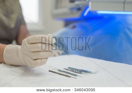 Close-up Of An Ophthalmologist Doctor Holding Instruments For Microscopic Eye Surgery In His Hand Ov