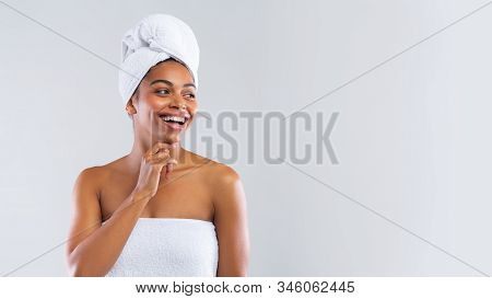 Amazing Offer In Spa. Happy Young African Woman Wrapped In White Bath Towels Looking At Copy Space, 