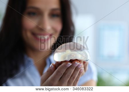 Focus On Breast Silicone Implants In Female Hands. Happy Cheerful Brunette Looking At Transparent Br