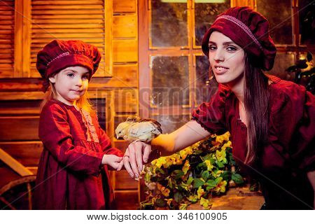 Easter And Family. Mother And Daughter In Maroon Or Red Dresses Of The Village Shepherdesses And Sma
