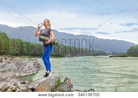 Blond Beautiful Strong Girl Standing On The Stone Cliff Ground Resting After Sport Outdoors Drink Te